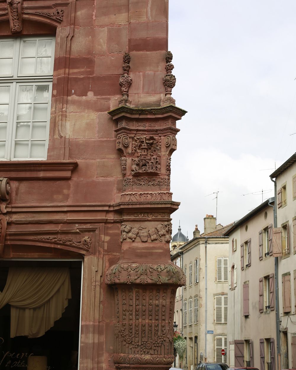 Façade sculptée en grès rose de la Maison du Marchand, dans une rue de Lunéville