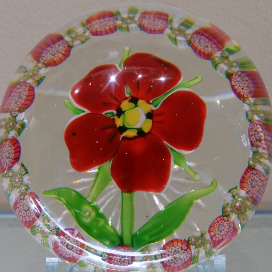 Presse-papier en cristal de Saint-Louis : une fleur rouge sur fond de filigrane blanc, cerclée de motifs roses
