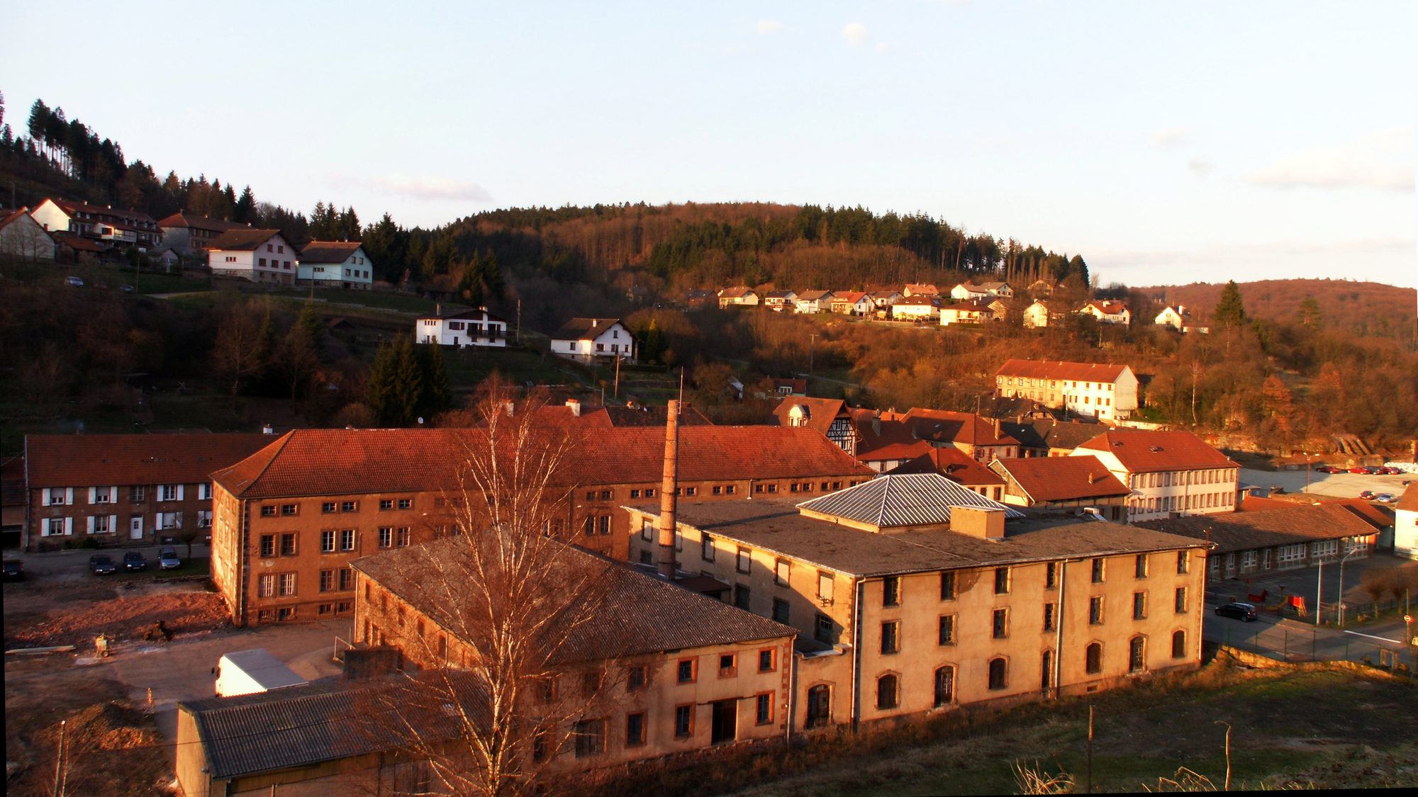 Les bâtiments des Cristalleries de Saint-Louis dans la vallée de Saint-Louis-lès-Bitche, au soleil couchant